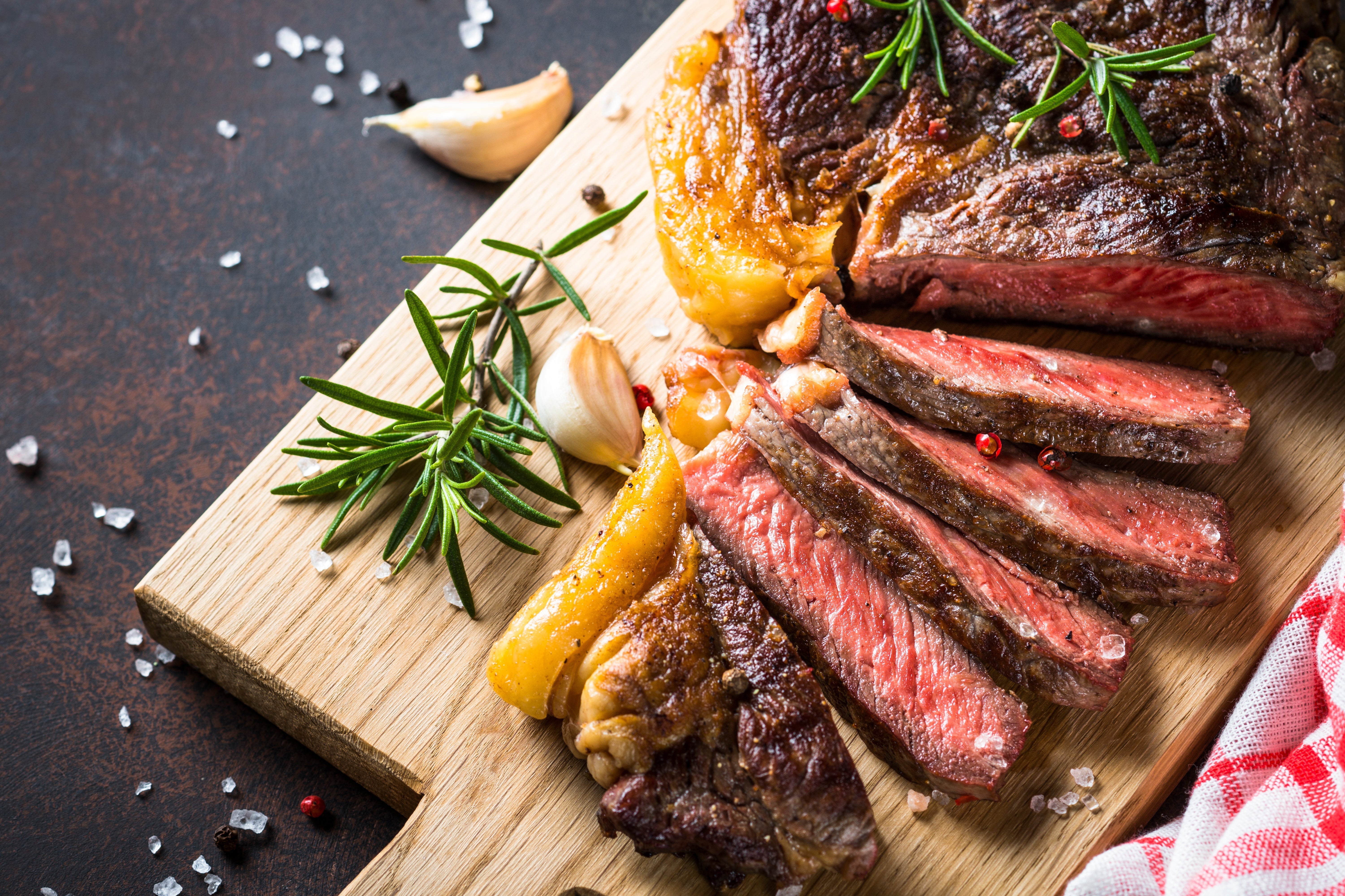 Grilled medium rare steak on a wooden platter